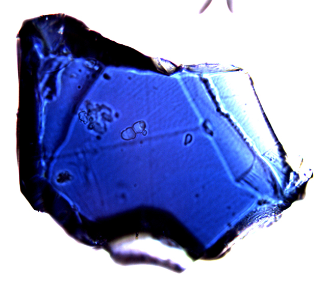 Crystal (~150 micrometers across) of Fo90 composition blue ringwoodite synthesized at 20 GPa and 1200 °C. 